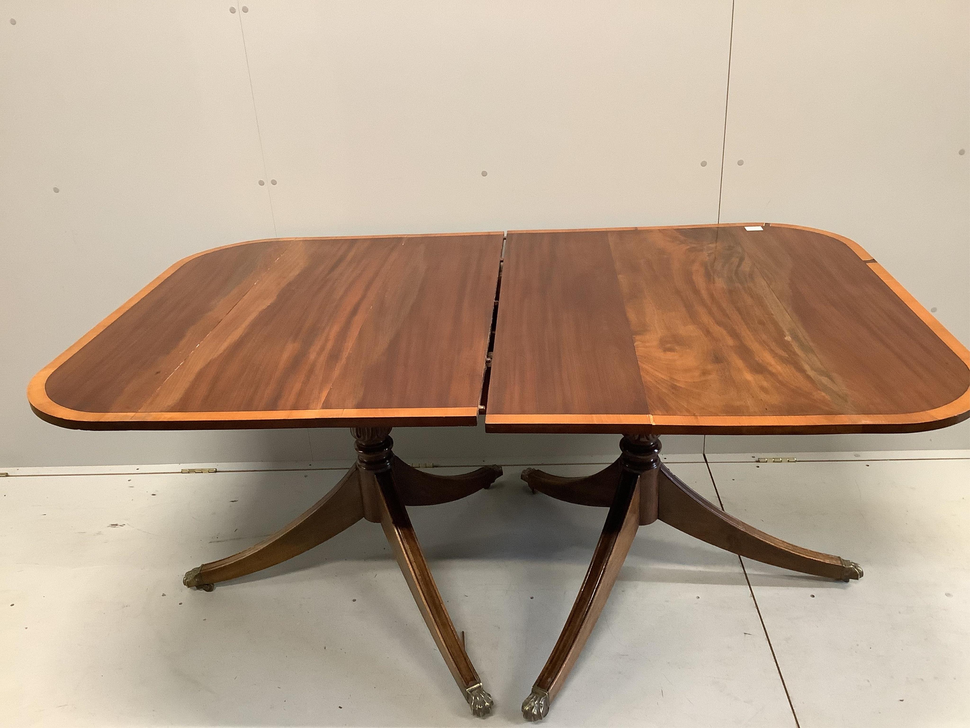 A George IV satinwood banded mahogany twin pedestal dining table, 223cm extended, one spare leaf, depth 106cm, height 74cm. Condition - fair to good